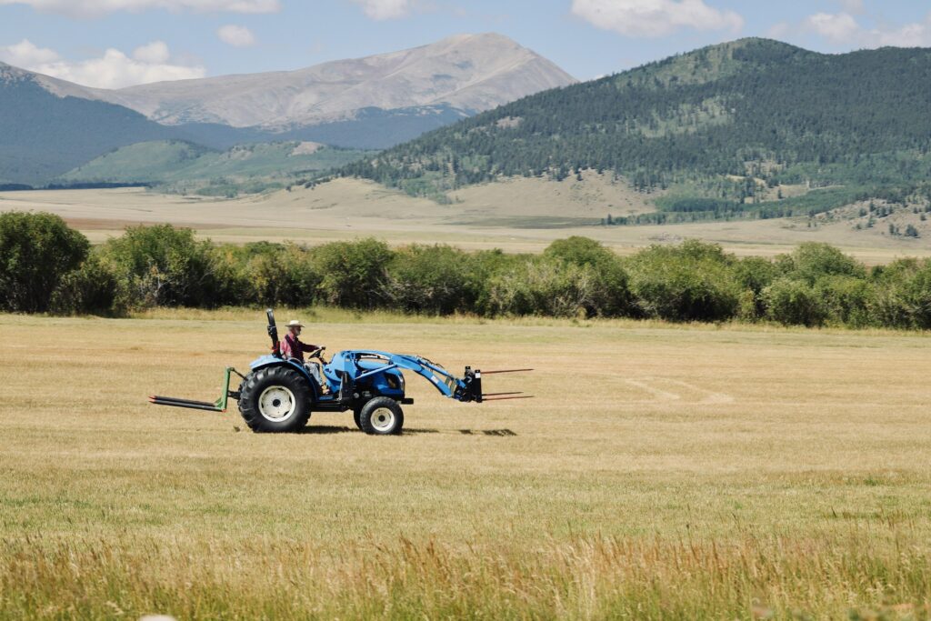 Tânăr fermier cu tractor în câmp - început de afacere agricolă