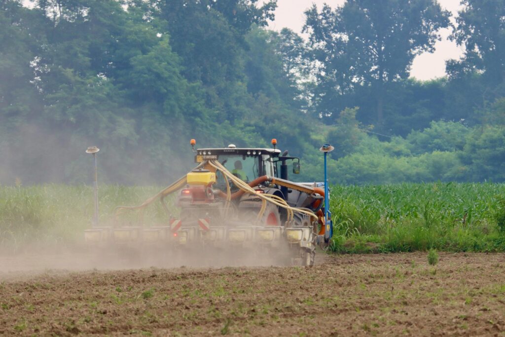 Tractor cu semănătoare de precizie lucrând pe un câmp de porumb primăvara în România